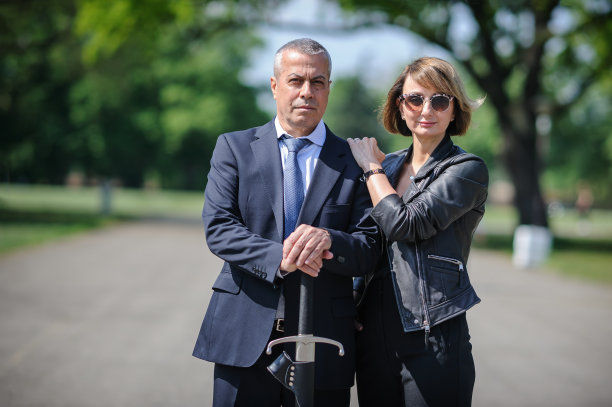 西装笔挺的商人用中世纪的大剑保护女人的爱情图片下载