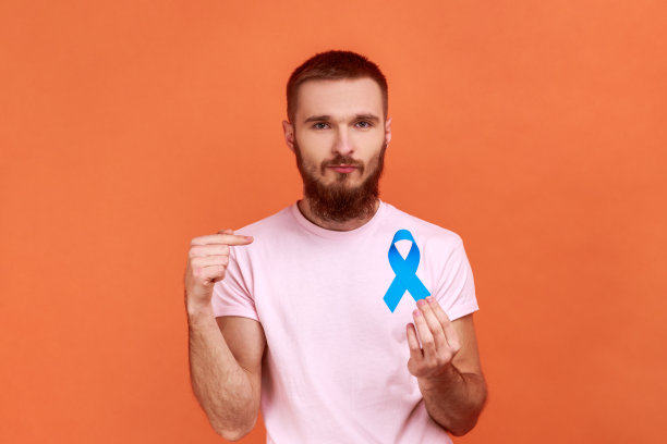 男人用手指着蓝色的意识，疾病的标志，看着镜头，支持。图片下载