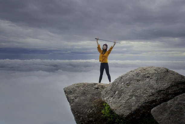 徒步旅行者与背包放松的年轻女子和看着惊人的山脉和森林，漫游旅行的概念，空间的文字，大气史诗时刻徒步度假图片下载