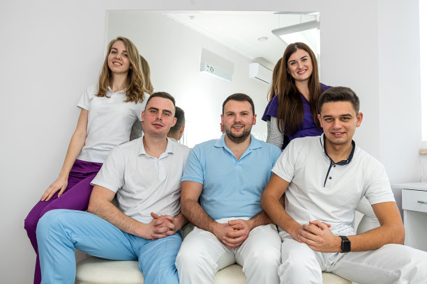 五位精力充沛的医学专家对着他们的病人微笑。图片下载