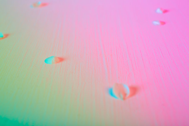 从粉色渐变到绿色色调的背景与落下的白色花瓣的樱桃或苹果树花。带有霓虹灯的复活节节日卡片。春天的壁纸。极简主义风格。新鲜的少女的颜色图片下载