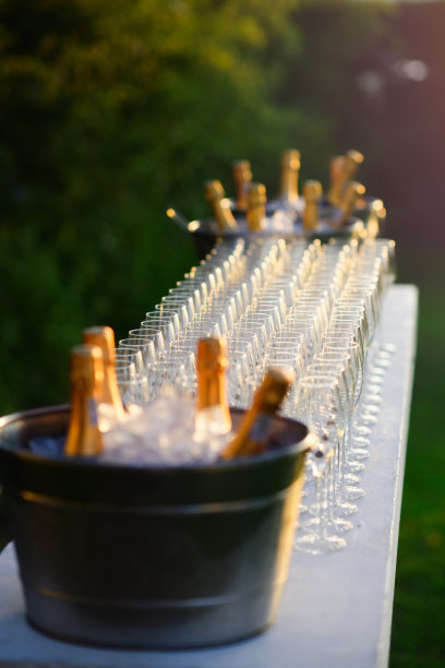 日落香槟长笛和香槟气泡酒瓶两侧图片下载