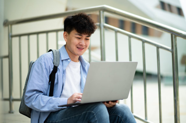 亚洲年轻帅哥在地铁站使用笔记本电脑图片下载