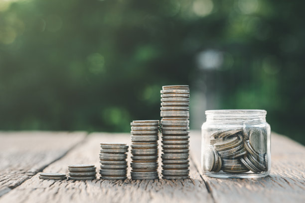 省钱投资理念。硬币堆叠生长图和硬币罐中玻璃。平衡储蓄利息和投资概念。业务策划及财务管理。图片下载