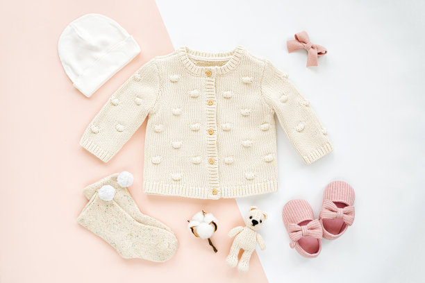 针织连体裤，袜子，玩具和可爱的婴儿拖鞋。一套新生儿的衣服和配件。平铺，俯视图图片下载