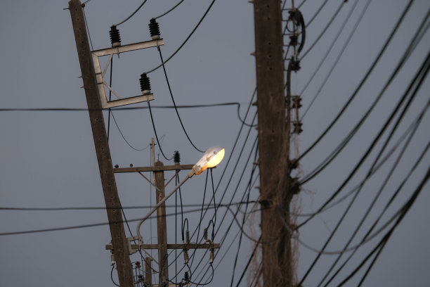 开灯的电线杆上的电线在晚上被弄乱了。高压危险图片下载