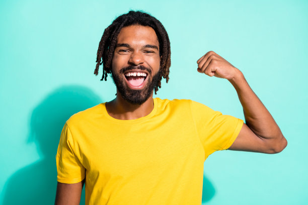 照片肖像强大的黑色皮肤男子屈二头肌一只手上鲜明的蓝绿色背景孤立图片下载