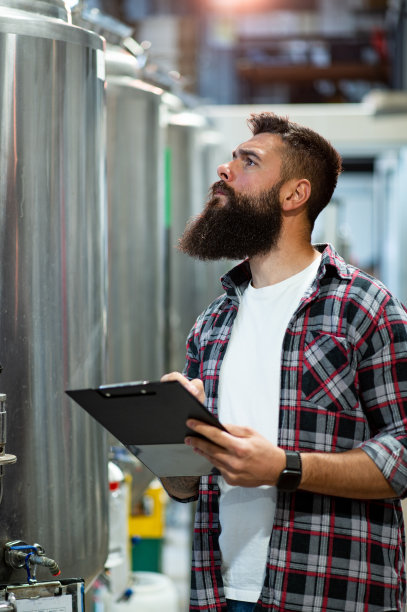 在啤酒厂工作并记录啤酒生产的人图片下载