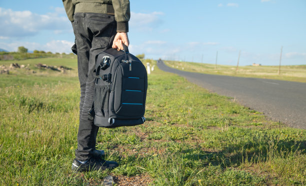 一个背着背包的男人站在路上。图片下载