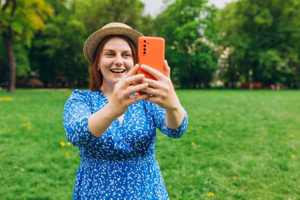美丽的黑发女子在夏季城市公园自拍肖像。无忧无虑快乐，阳光灿烂夏日心情。在线交流的概念图片下载