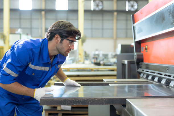 工人在冶金工业工厂用现代切割机切割金属板图片下载
