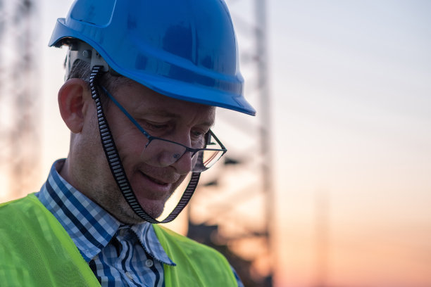 自信的男技术员在发电站前的肖像。图片下载