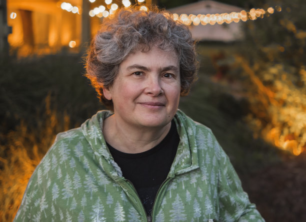 微笑迷人的中年妇女户外头像，背景有装饰灯图片下载