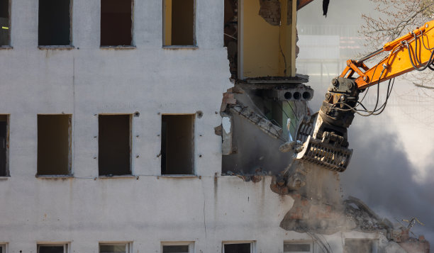 挖掘机铲斗拆除旧建筑的特写。图片下载