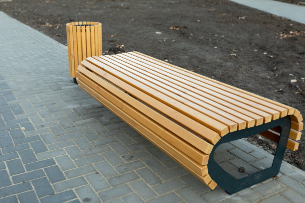 一个现代舒适的没有靠背的木凳和一个用木板条做成的垃圾桶在一个新的住宅区。对房屋领土的美化图片下载