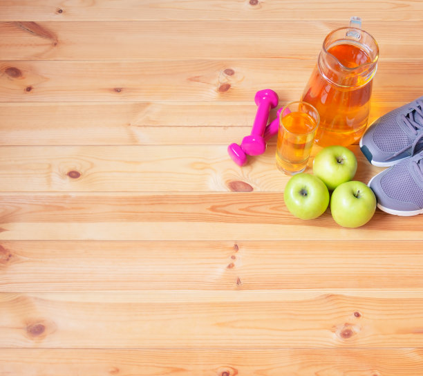 运动鞋，苹果汁，哑铃和木制背景的苹果图片下载