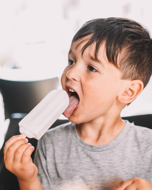 男孩在享受椰子冰淇淋图片下载