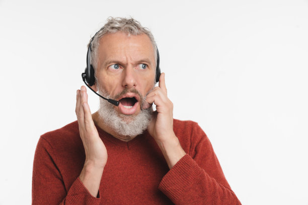 惊讶震惊印象深刻的白人成熟中年男子操作员自由职业者it支持经理与客户交谈客户，在白色背景隔离的耳机咨询。热线工作图片下载
