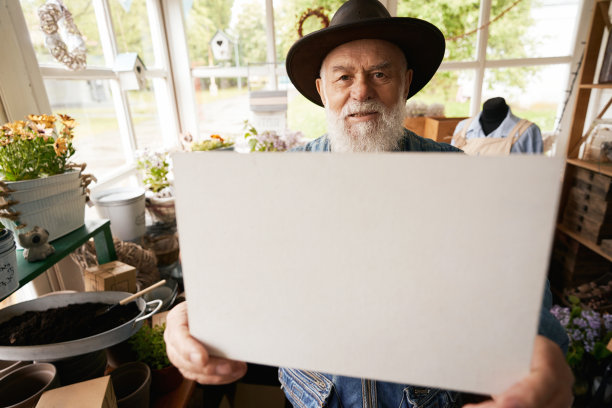 花店里拿着一张纸的老人图片下载