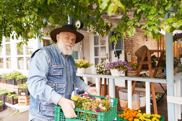 上了年纪的男花商，带着盆栽花盆到户外图片下载
