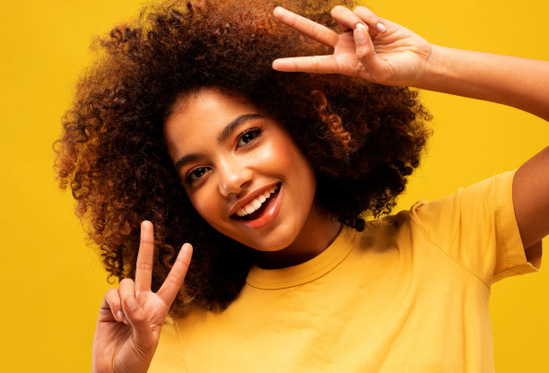 闪亮的非洲妇女穿着黄色t恤显示v字图片下载