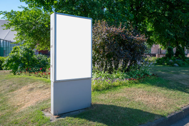 夏天，在城市公园草坪上竖立着一个空白的垂直灯箱图片下载