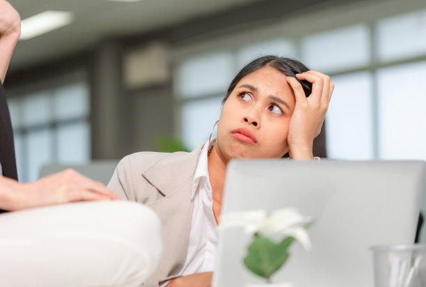 肖像的女人看着她的同事与不满意的表情，在她的办公室工作的女人图片下载