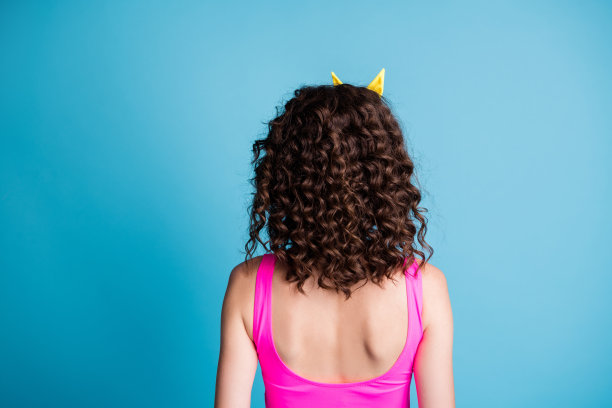 背部背部脊柱视图照片波浪头发的女人穿粉红色背心孤立在淡蓝色的背景图片下载