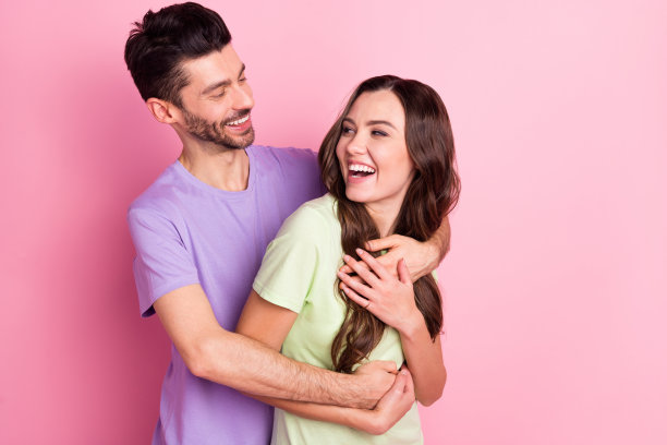 有吸引力的肖像高兴温柔愉快的夫妇拥抱有乐趣孤立在粉红色粉彩背景图片下载