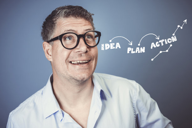 蓝色衬衫的中年男子在蓝色背景下摆姿势图片下载