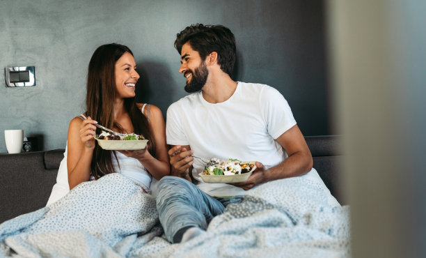 相爱的情侣在床上吃早餐。人，爱，食的概念。图片下载