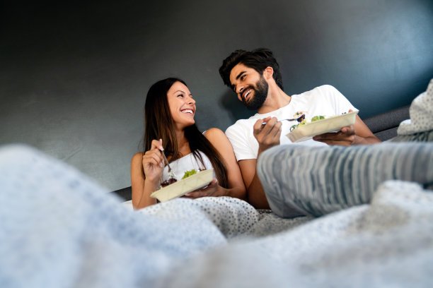 在床上吃健康早餐。年轻美丽的情侣相爱在一起。早上好。图片下载