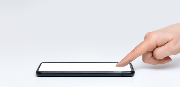 女人在手机的空白屏幕上轻敲。白色桌子上的智能手机，空白触摸屏上的女性手和手指。女人手指按屏幕图片下载