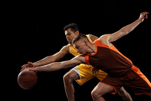 两个专注的男人的肖像，运动中的篮球运动员，运球孤立在黑色的演播室背景图片下载