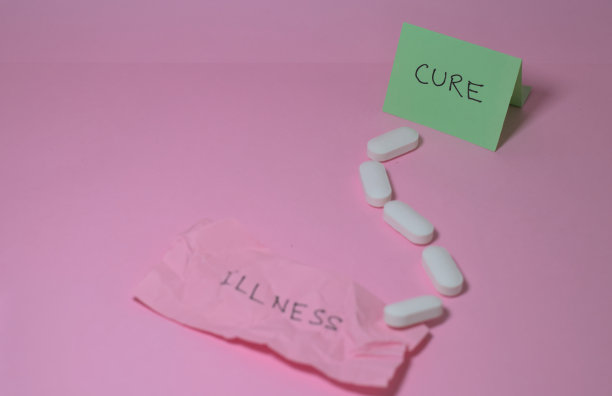 白色的药物正在走向一个手写的“治愈”的标志。粉红色的背景。图片下载