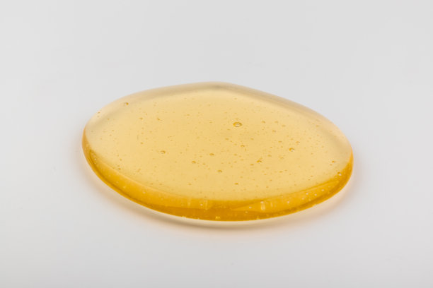 蜂蜜流。黄色的糖浆滴下来。天然产品和甜饮料。孤立在白色背景。图片下载