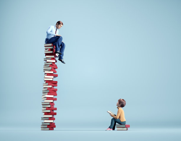 在一堆书里的孩子会仰望一个在更大一堆书里的成年人。老师和学生。图片下载