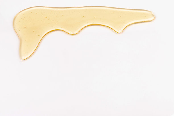 蜂蜜流。黄色的糖浆滴下来。天然产品和甜饮料。孤立在白色背景。图片下载