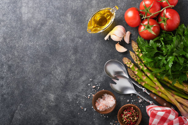 欧芹，欧芹，番茄，大蒜，橄榄油，胡椒粉，盐和沙拉叉子和勺子在黑石烹饪背景。食物烹饪的背景。烹饪食物背景的配料。模拟。图片下载
