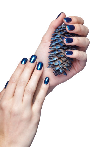 女性双手与蓝色的圣诞冷杉锥和闪亮的指甲指甲孤立在白色图片下载
