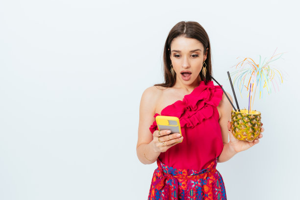 惊讶的年轻女子手持节日菠萝鸡尾酒饮料图片下载