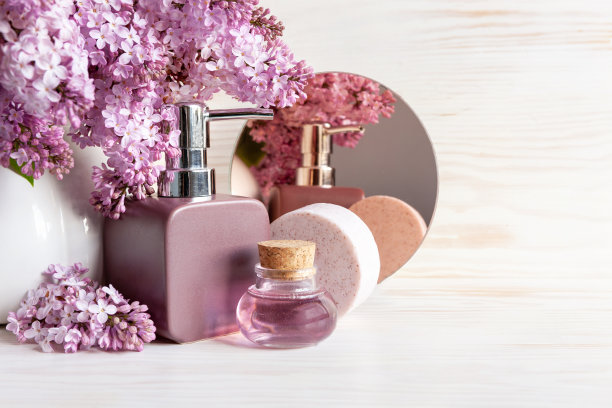 浴室分配器，香皂，丁香精华和丁香花。水疗、美容健康沙龙、化妆品店概念。图片下载