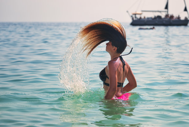 美丽的年轻女孩在海滩上玩得很开心图片下载