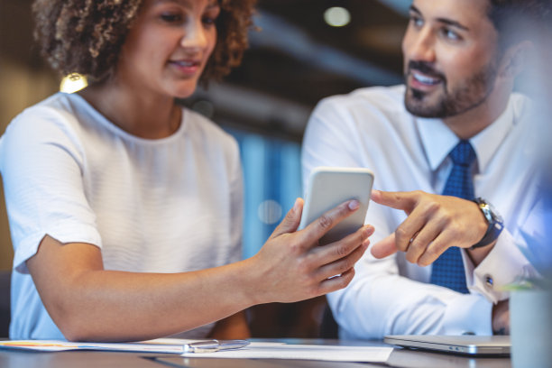 商务男男女女在办公室工作，看着手机。图片下载