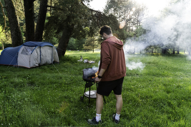 一个在森林里露营的人正在烧烤。图片下载