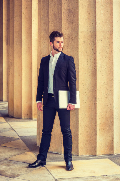 一个年轻人站在纽约市的办公楼外图片下载