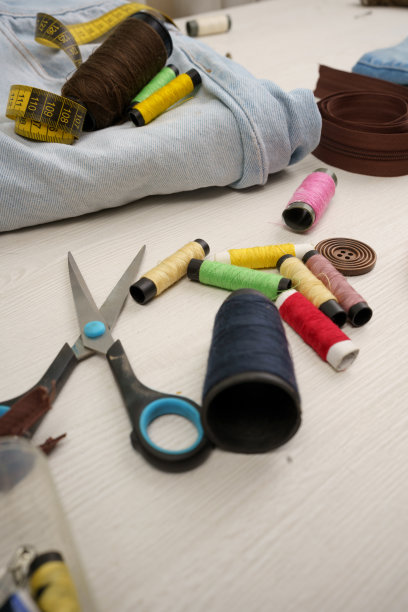 有彩线工作台、剪刀、布匹和卷尺，有仪器的缝纫车间图片下载