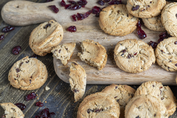 桌上有优质面粉制成的美味干曲奇饼和干红蔓越莓图片下载