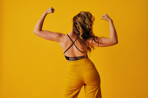 一个美丽的年轻女子在夏天跳舞展示手臂肌肉的背面照片图片下载
