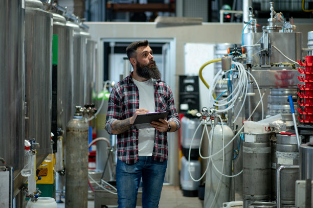在啤酒厂工作并记录啤酒生产的人图片下载